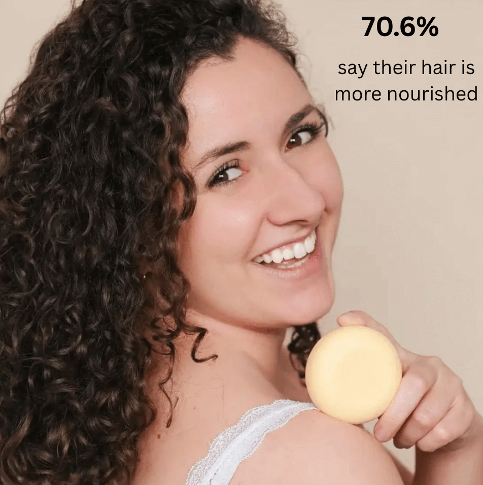 Smiling woman with curly hair holding solid shampoo, highlighting natural curly hair care benefits.
