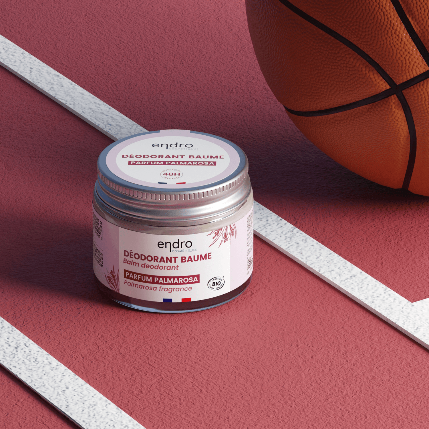 Solid natural deodorant in a jar on a basketball court, featuring aluminium-free, clean beauty formula with palmarosa scent.