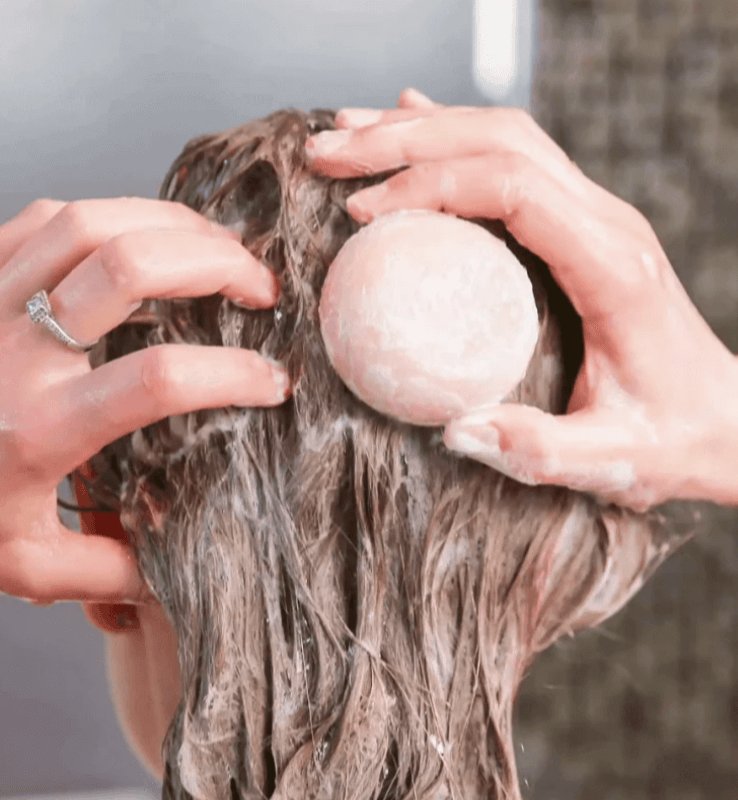 Applying solid shampoo for dry hair to nourish and hydrate with natural ingredients, sulfate-free clean beauty.